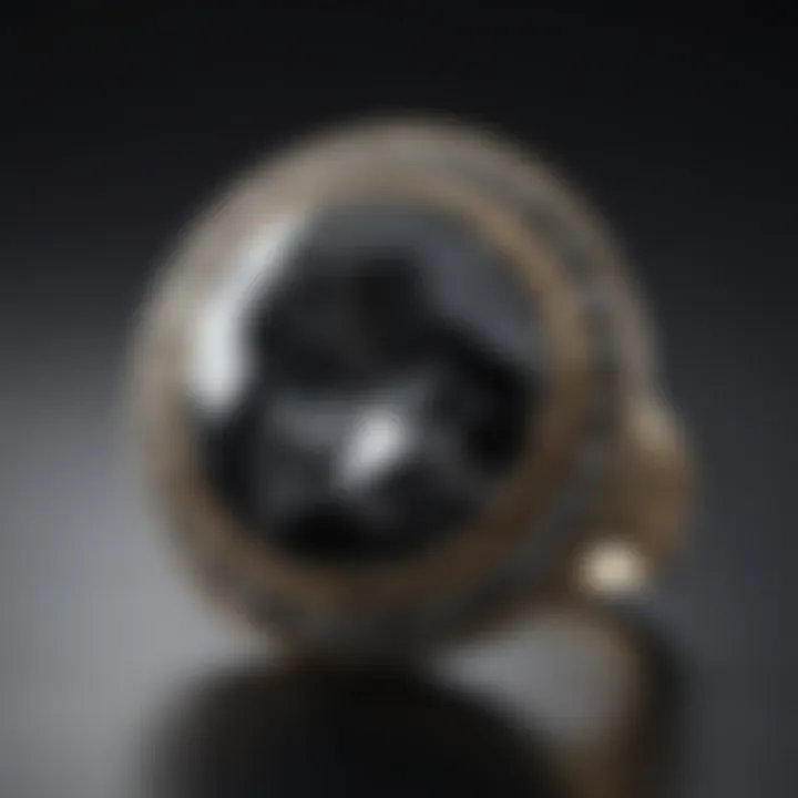 Black crystal with grey spots displayed in a jewelry setting